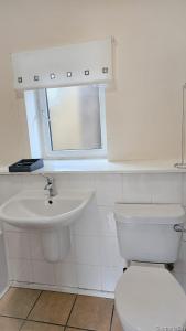 a white bathroom with a toilet and a sink at 12A-2 Stobhill Road in Arniston +21 photos