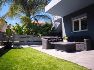 a patio with two couches and a table in a yard at ΛΝΛPliON home in Nafplio