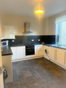 a kitchen with white cabinets and a dishwasher at 12A-2 Stobhill Road in Arniston