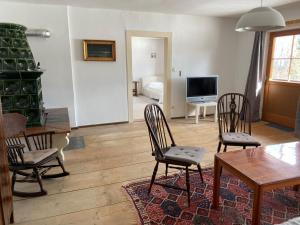 a living room with chairs and a table and a television at Nusshof in Berchtesgaden