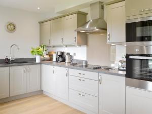 a kitchen with white cabinets and stainless steel appliances at Veleta in Grange