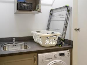 a kitchen counter with a sink and a washing machine at Veleta in Grange