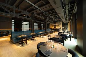 a restaurant with tables and chairs in a room at Palazzo Loreto Hotel Milano in Milan