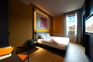 a bedroom with a bed and a large window at Palazzo Loreto Hotel Milano in Milan +23 photos