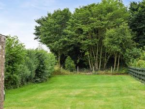 a large yard with a fence and trees at The End Hoose in Duns
