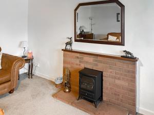 a living room with a fireplace and a mirror at The End Hoose in Duns +11 photos