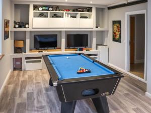 a pool table in a room with a tv at Cefn Y Gwynt in Llangranog