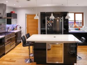 a kitchen with a large island with a white counter top at Cefn Y Gwynt in Llangranog +17 photos