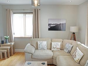 a living room with a couch and a table at Cefn Y Gwynt in Llangranog