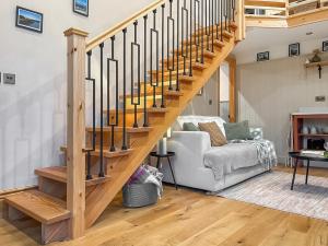 a wooden staircase in a living room with a white couch at The Coal House in Skipton