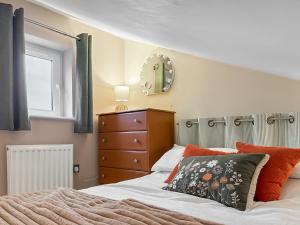 a bedroom with a bed and a dresser and a mirror at The Coal House in Skipton