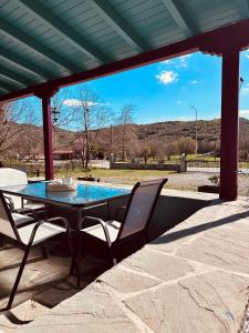 a patio with a table and chairs and a pool at Λαμπρινής Guest House-Zagori in Asprangeloi