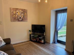 a living room with a tv and a lion picture on the wall at Serenity- Uk38551 in Endon