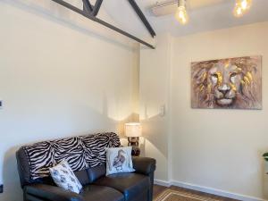 a living room with a couch and a painting of a lion at Serenity- Uk38551 in Endon