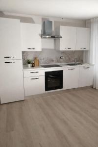 a white kitchen with white cabinets and a sink at Light Loft Marsciano in Marsciano