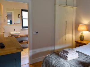 a bedroom with a bed and a bathroom with a sink at Strathspey in Grange +19 photos