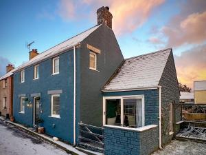 a blue and black house sitting on a street at Oystercatcher Cottage in Haverfordwest