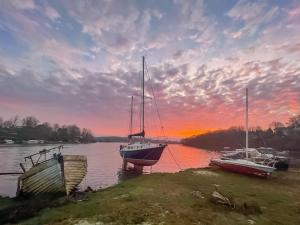 three boats are docked on the water at sunset at Oystercatcher Cottage in Haverfordwest