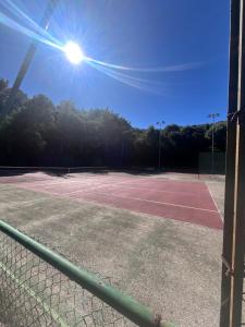 a tennis court with the sun shining on it at Capo d'Arco Residence Bilocale tra Mare e Natura in Capo D'Arco