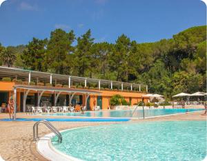 a large swimming pool in front of a resort at Capo d'Arco Residence Bilocale tra Mare e Natura in Capo D'Arco