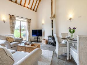 a living room with a couch and a table at Chapel Barn - Uk46738 in Shapwick +9 photos