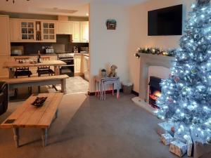 a living room with a christmas tree and a fireplace at Trebor Cottage in Annan