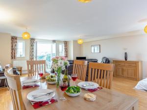 a dining room and living room with a table and chairs at 6 Harbour View in Newquay