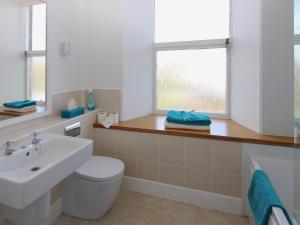 a bathroom with a sink and a toilet and a window at The Townhouse in Inverness +4 photos