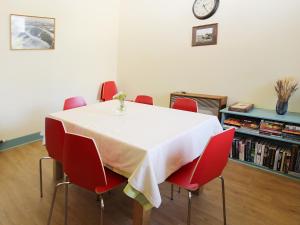 a dining room table with red chairs and a clock at The Townhouse in Inverness
