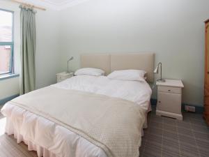 a bedroom with a large white bed and a window at The Townhouse in Inverness