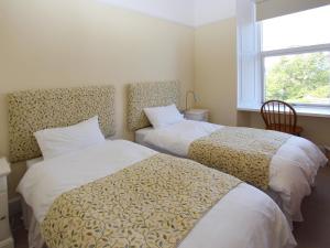 two beds in a room with a window at The Townhouse in Inverness