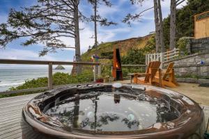 a hot tub on a deck next to the beach at Ocean's Edge in Tillamook