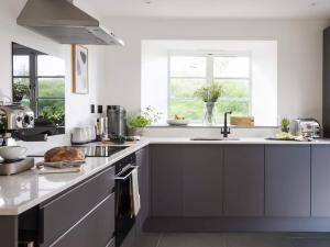 a kitchen with white counters and a sink at Acacia in West Worlington