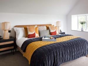 a bedroom with a large bed with colorful pillows at Acacia in West Worlington