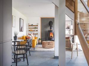 a living room with a yellow couch and a fireplace at Acacia in West Worlington