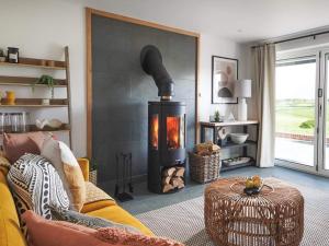a living room with a fire place in the wall at Acacia in West Worlington