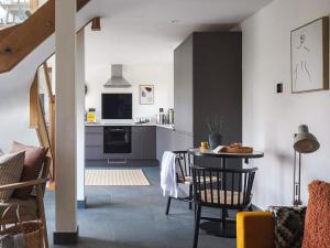 a living room with a table and a kitchen at Acacia in West Worlington +8 photos