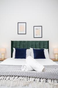 a bedroom with a large bed with blue pillows at Vacant Nests The Ropery 4BR Seafront in Seaham