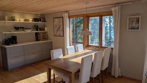 a dining room with a wooden table and white chairs at Stunning Waterfront Property in the Outer Archipelago in Kyrkkobben