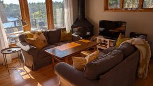 a living room with two couches and a table at Stunning Waterfront Property in the Outer Archipelago in Kyrkkobben