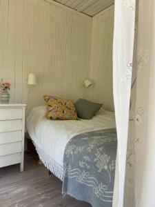 a bedroom with a bed and a dresser and a bed sidx sidx at Stunning Waterfront Property in the Outer Archipelago in Kyrkkobben