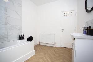 a white bathroom with a tub and a sink at Vacant Nests The Ropery 4BR Seafront in Seaham +44 photos