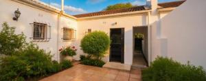 a white house with a courtyard at Rus en Vrede BackPackers Cottage! in Knysna