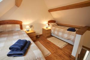 two twin beds in a room with two lamps at Barn Cottages at Lacock in Lacock