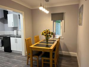 a kitchen with a table with a vase of flowers on it at Haven In The Burn in Newburn