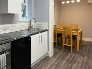 a kitchen with a sink and a table with chairs at Haven In The Burn in Newburn +14 photos