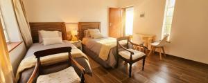a hotel room with two beds and a chair at Rus en Vrede BackPackers Cottage! in Knysna
