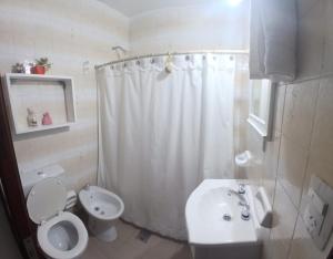 a white bathroom with a toilet and a sink at Rincon bonito in Salta