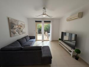 a living room with a couch and a flat screen tv at Elysia Park Star in Paphos