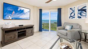 a living room with a large screen tv and a chair at Coastal Joy 3412 Ocean Pointe in Tavernier
